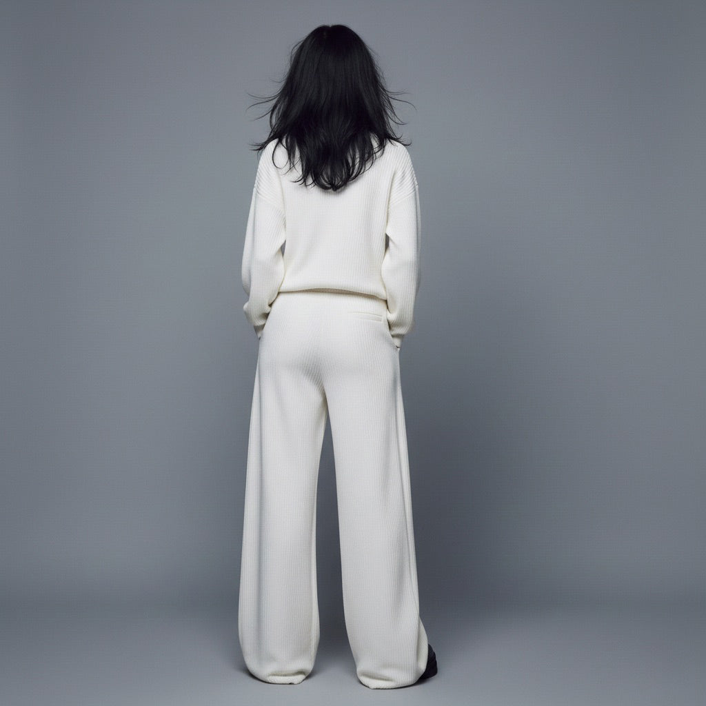 Person wearing a white outfit against a gray background