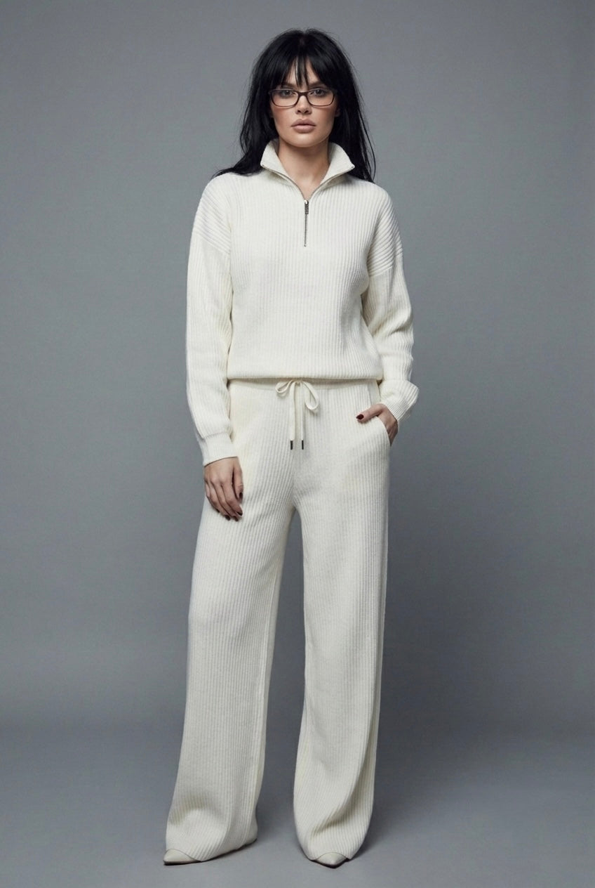 Person wearing a white tracksuit against a gray background