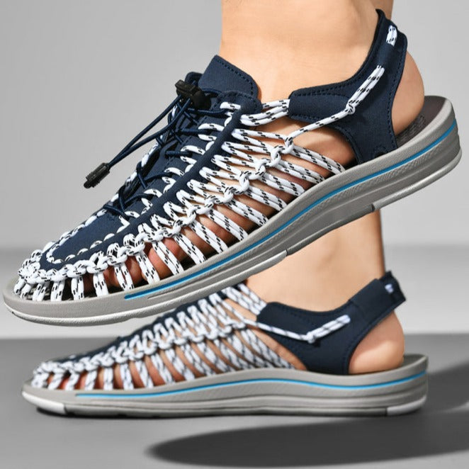 Navy sandals with white mesh design on a gray background