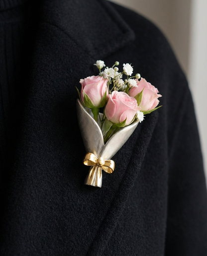 Floral boutonniere on a black coat with a gold bow