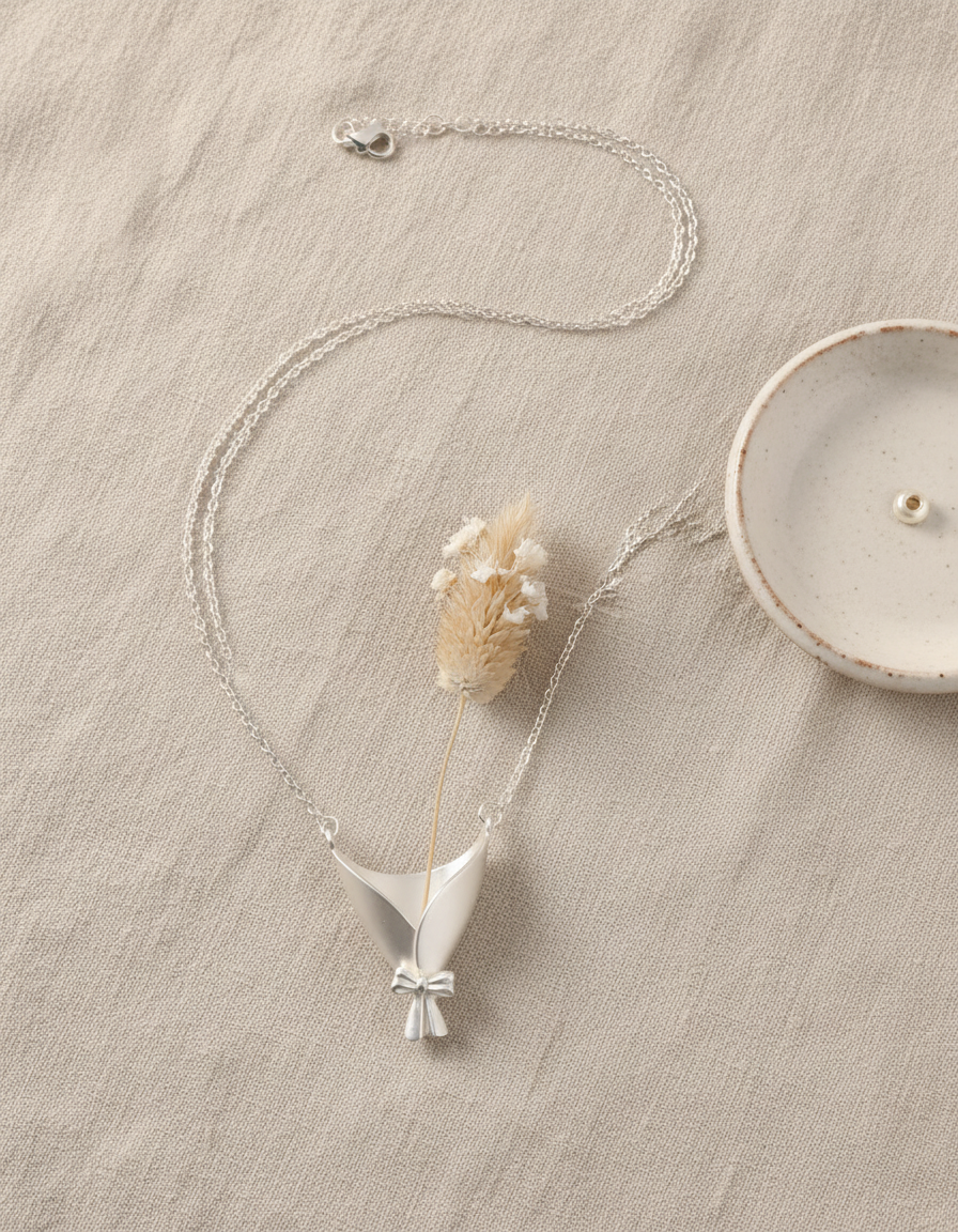 Silver necklace with a unique pendant on a textured surface