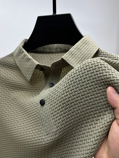 Green textured shirt on a hanger with a hand holding it