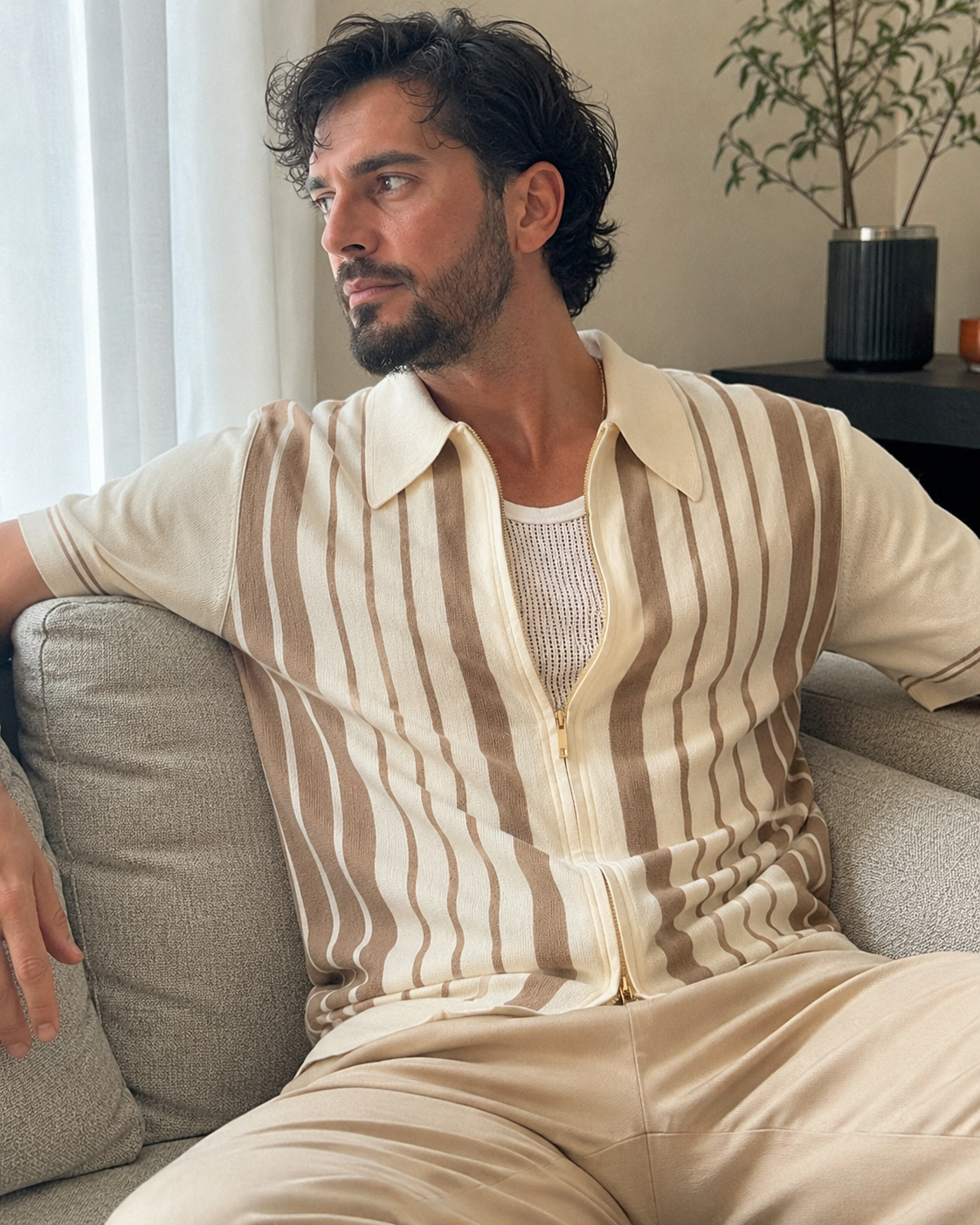Amateur living room style photo of a man aged around 28 to 38 wearing the Riviera striped cotton knit zip polo