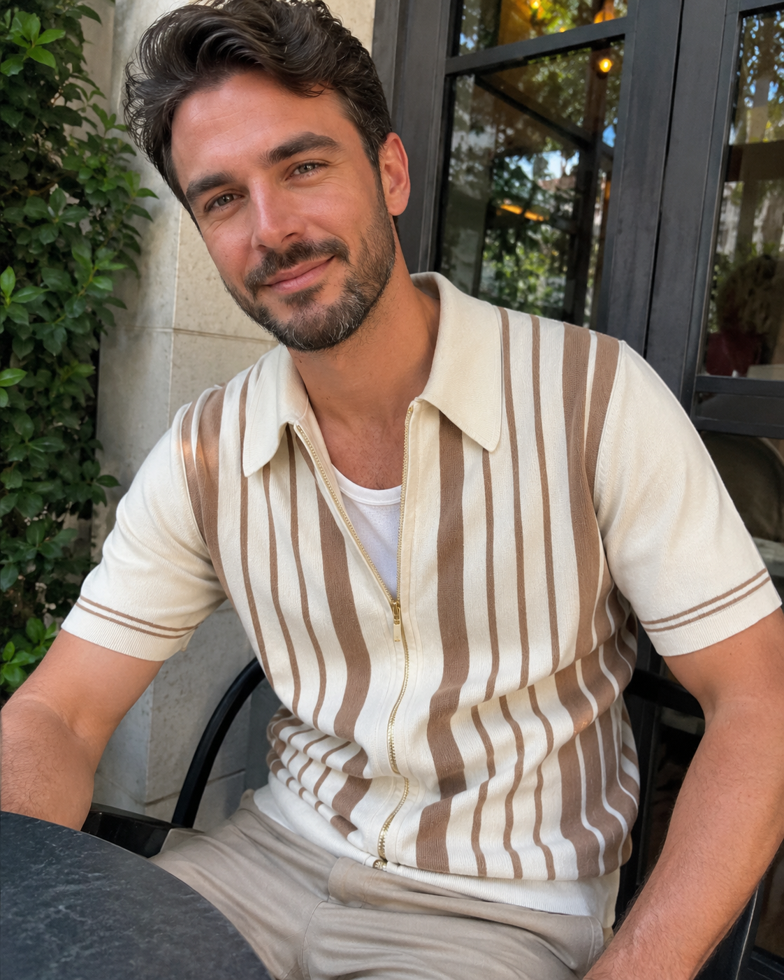 Café natural light style photo of a man aged around 28 to 38 wearing the Riviera striped knit zip polo