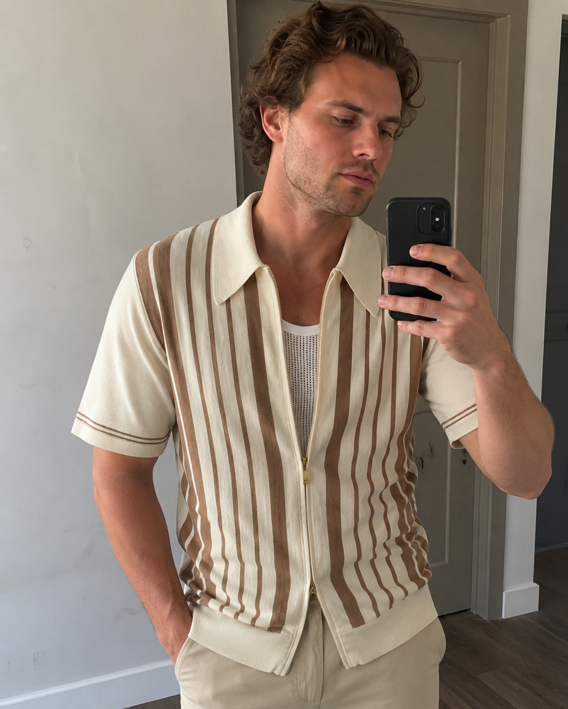 Neutral room selfie style photo of a man aged around 28 to 38 wearing the Riviera striped cotton knit zip polo