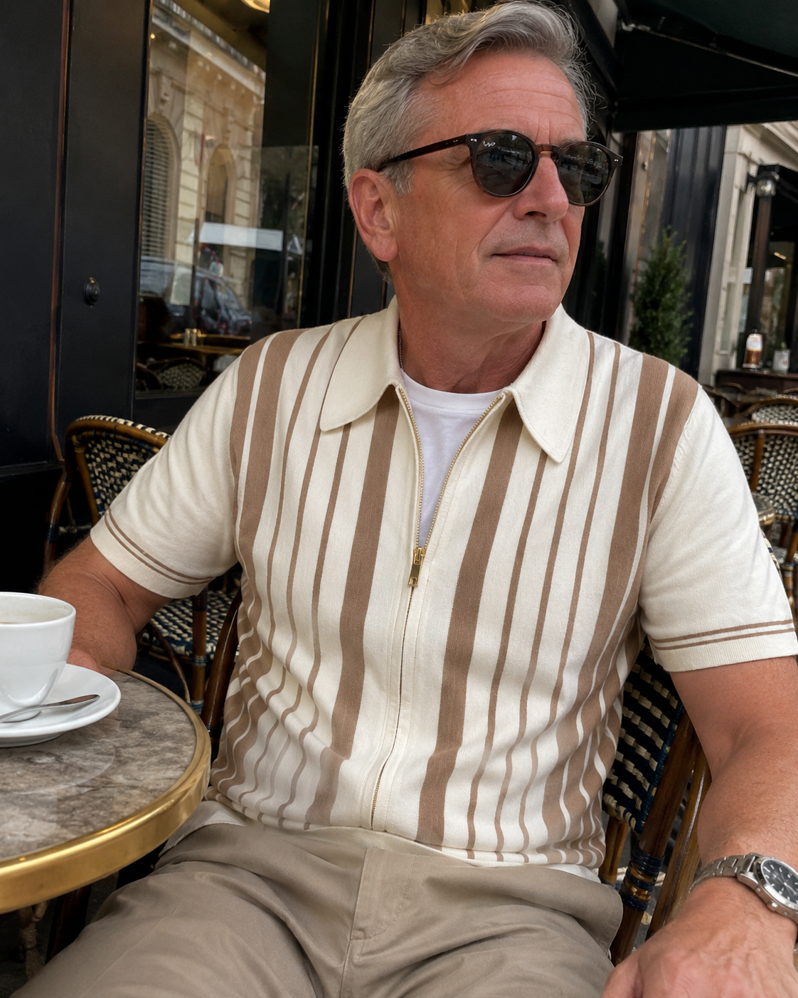 Café daylight style photo of a man over 40 wearing the Riviera striped knit zip polo