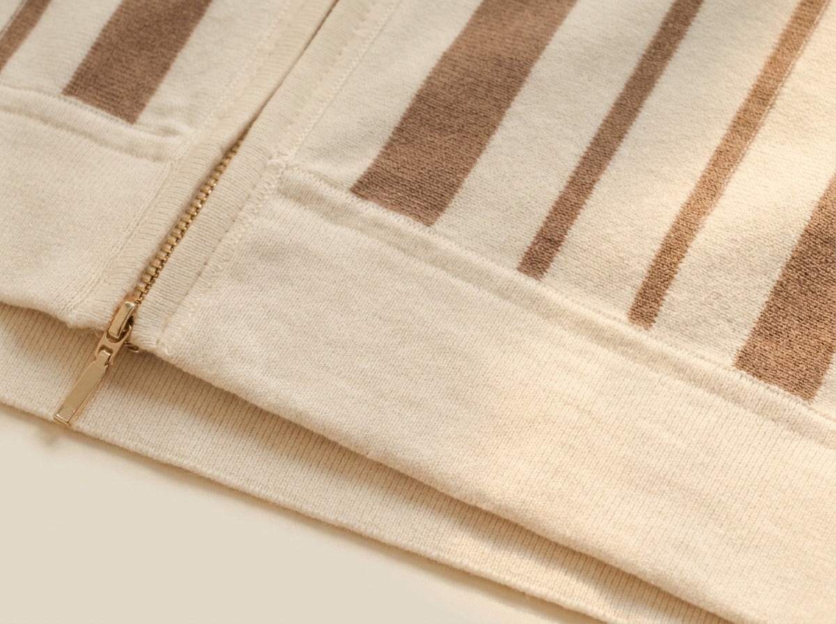 Macro detail of cream cotton knit fabric with brown stripes and zipper