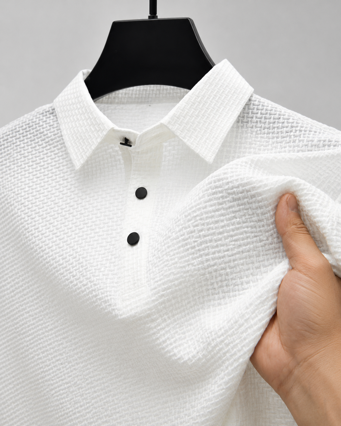 Close-up of the white Siena Weave Polo Shirt showing the raised woven texture and black buttons