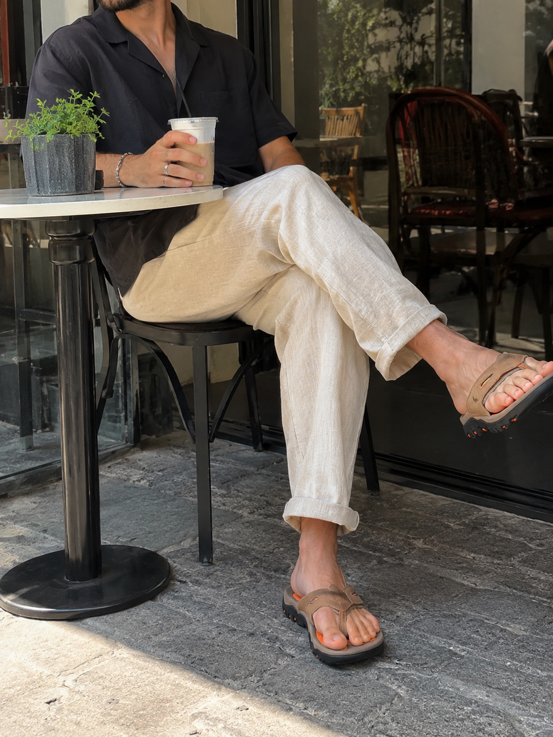 Sunny café outfit reference wearing brown Sorrento Leather Sandals with light trousers