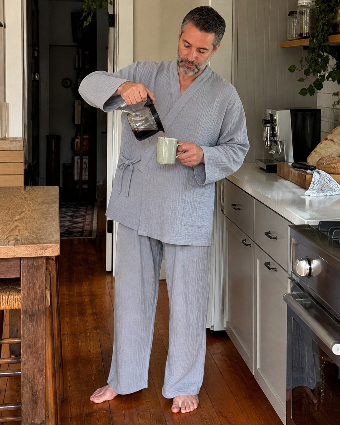 Man wearing the grey Yoake Kimono Set while making coffee