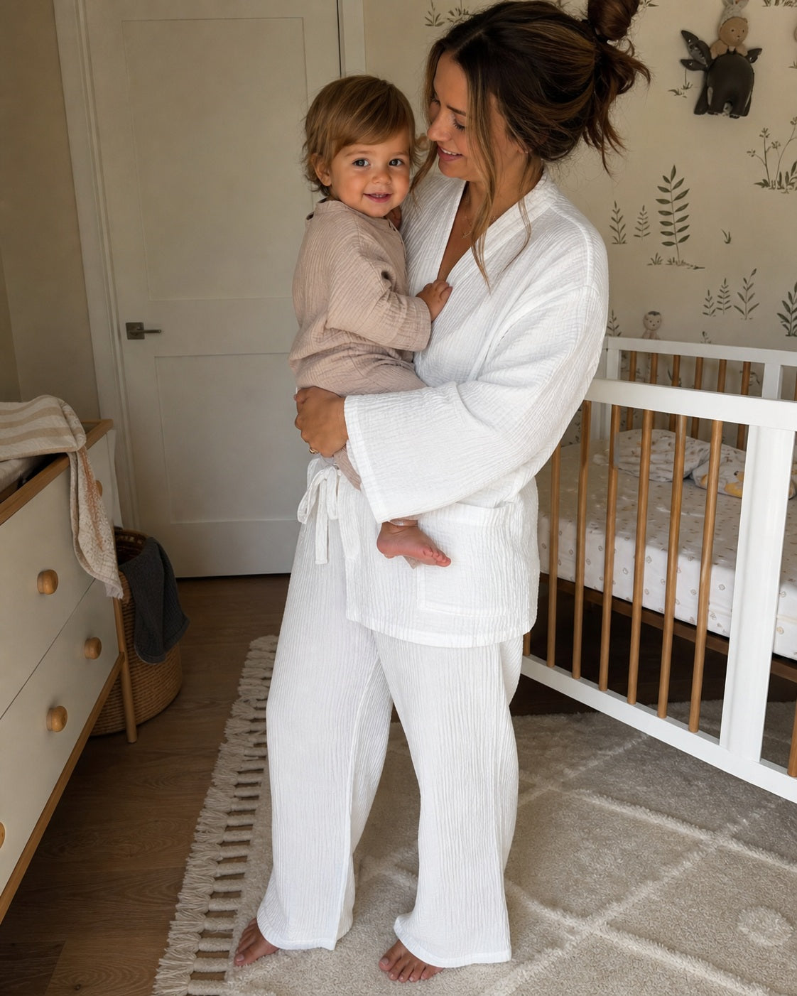 Mother wearing the white Yoake Kimono Set while holding her child
